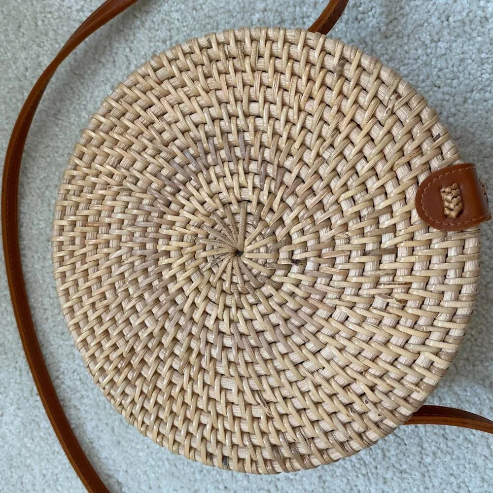 Round solid rattan woven crossbody purse cloth lined, leather accents.